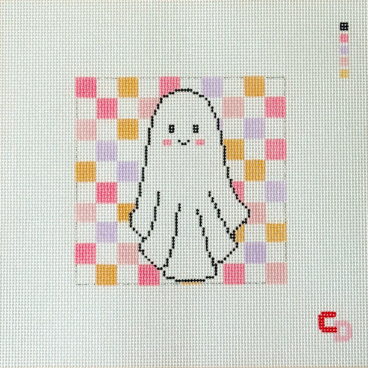 A completed needlepoint canvas featuring a cute white ghost with a black outline, pink cheeks, and a pastel pink, purple, and orange checkered background. The canvas is framed by a beige border printed with the brand name 'Catswold'.